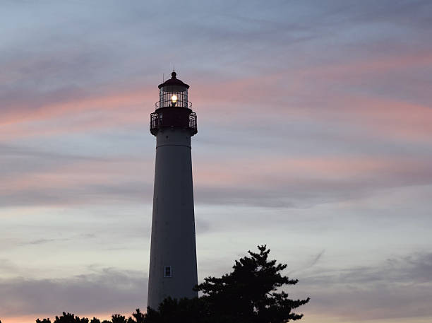 phare au coucher du soleil - dark light beam beacon projection photos et images de collection