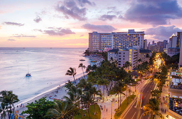 playa de waikiki y kalakaua avenue en honolulu, hawai en la noche - waikiki beach fotografías e imágenes de stock