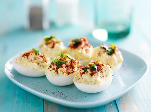 deviled eggs with paprika deviled eggs with paprika and green onion garnish Deviled Egg stock pictures, royalty-free photos & images