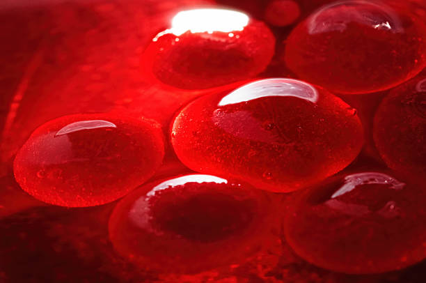 Red jelly-like globules Bright red jelly-like globules in aqueous solution, with trapped air pockets. colloid stock pictures, royalty-free photos & images