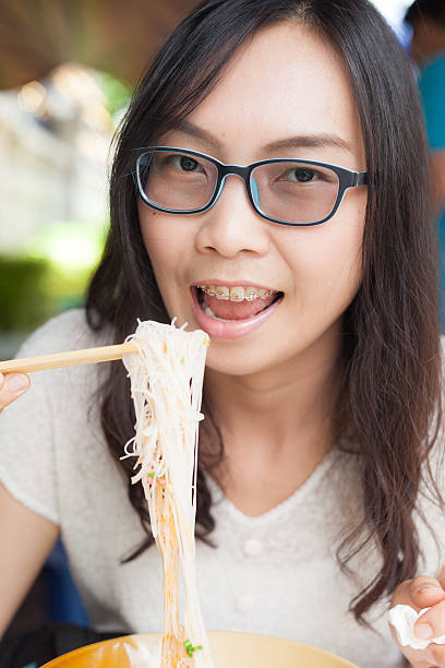 istock woman eat noodles. 491172728