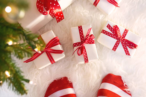 istock Feet with striped socks with Christmas gift boxes 491173422