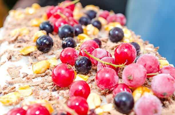 young woman cuts the cake with frozen berries