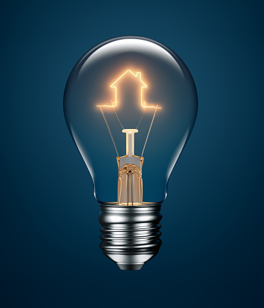 Light bulb with filament forming a house icon on blue background