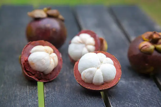 mangosteens on a wooden table, close up image