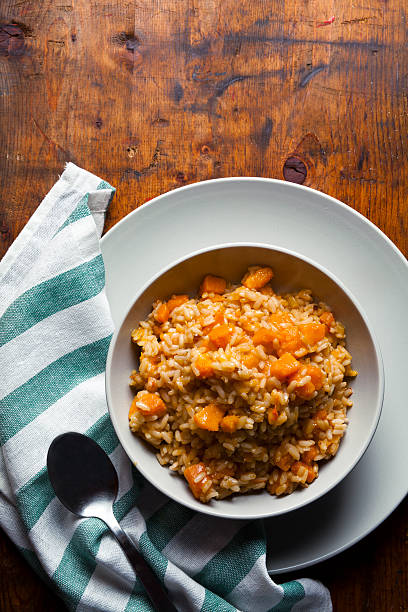 istock risotto with pumpkin on a wooden table texture. 491190730
