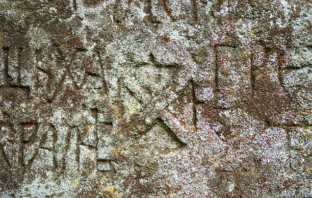 istock Moss-grown surface of the old stone cross 491191050