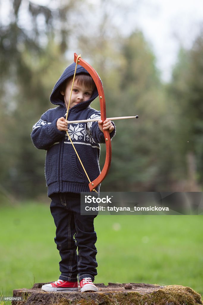 Boy shoots with bow at a target, Boy shoots with bow at a target, in the open air Child Stock Photo