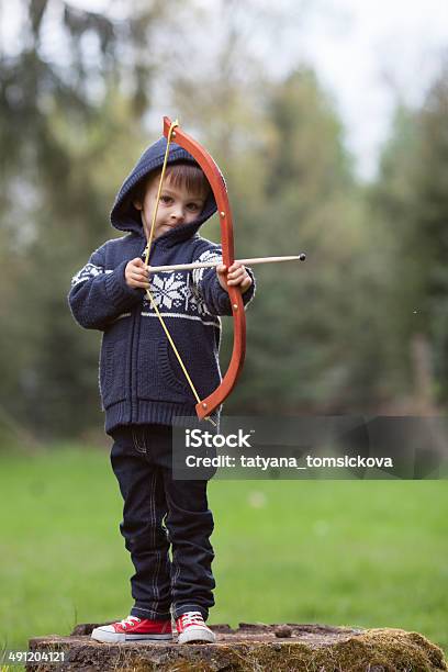 Boy Shoots With Bow At A Target Stock Photo - Download Image Now - Child, Archery, Archery Bow