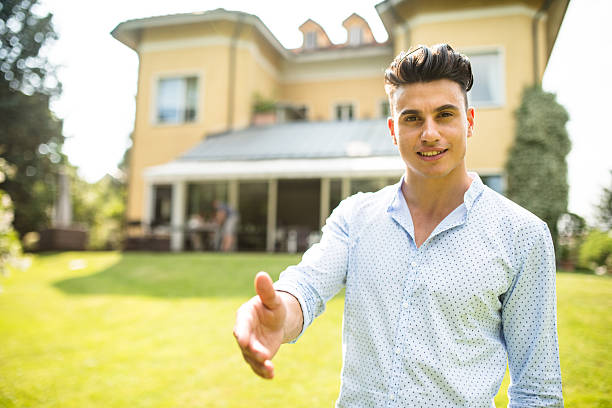 istock Owner in front of his villa showing it 491217052