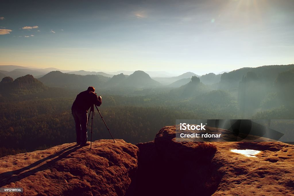 Profesional acantilado. Naturaleza fotógrafo toma fotos con espejo de la cámara - Foto de stock de Operador de cámara libre de derechos