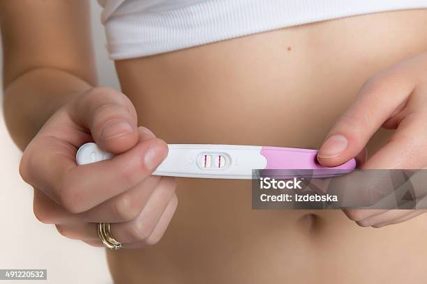 Woman Holding Positive Pregnancy Test Stock Photo - Download Image Now - Pregnancy Test, 2015, Adult
