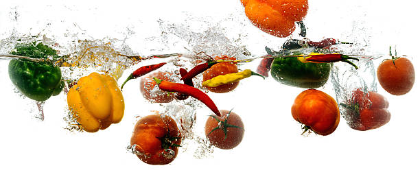 istock Capsicum, tomatos and bell peppers splashing into water 491223626