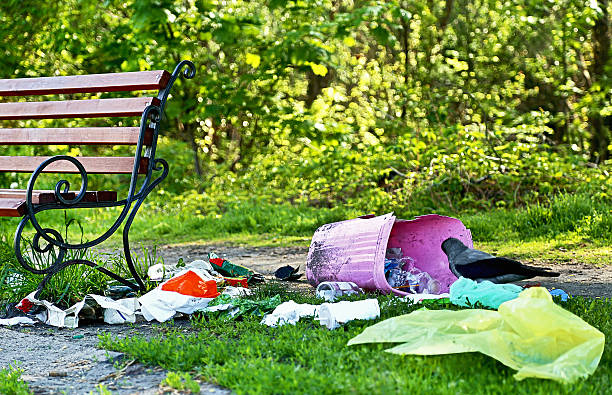 a poluição. problema ambiental. (depósito) de lixo perto de banco no parque. - dirty bench empty park - fotografias e filmes do acervo