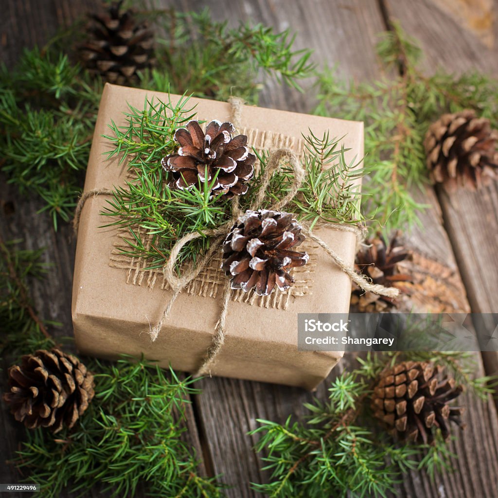 handmade gift for Christmas gift decorated with pine cones on the wooden background 2015 Stock Photo