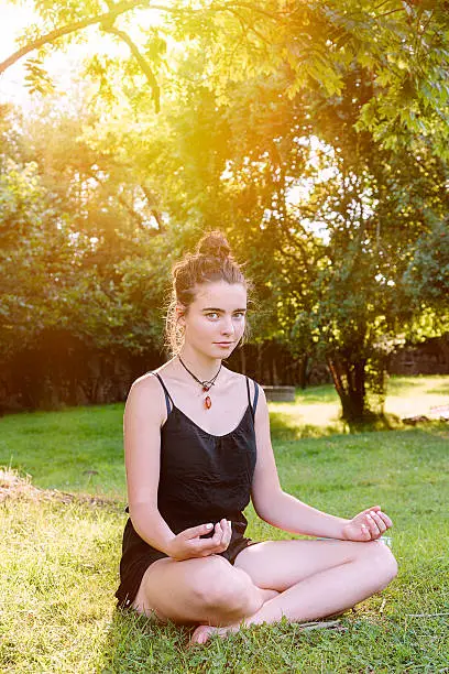 beautiful teenage girl meditates in nature