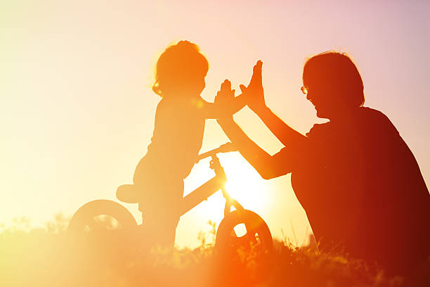 istock father and daughter having fun riding bike at sunset 491231468
