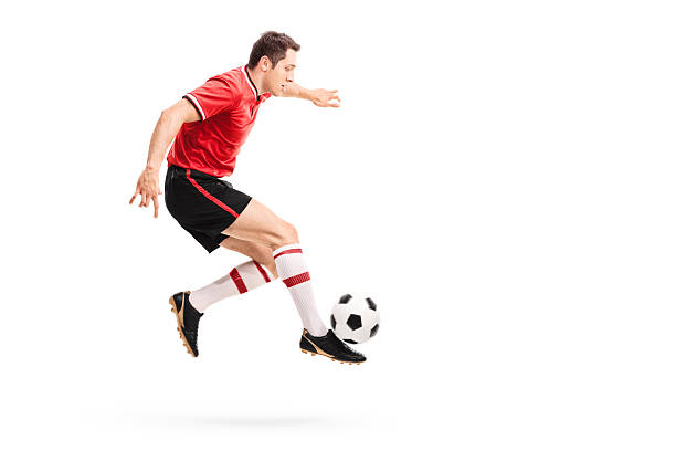 joven atleta salto y coleando de fútbol - volley kick fotografías e imágenes de stock