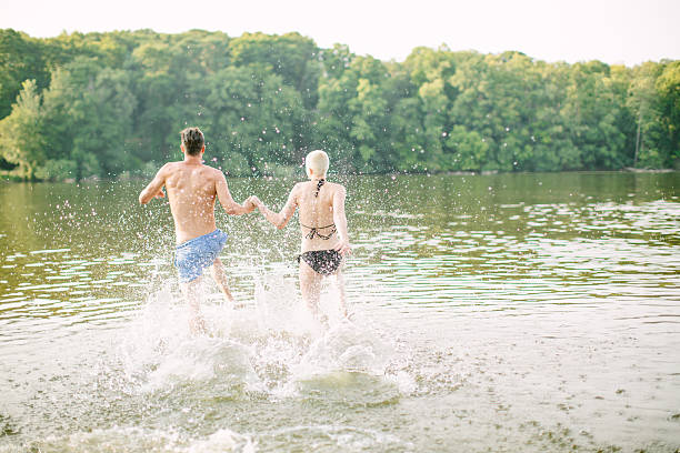 istock Young couple running into the lake 491232144