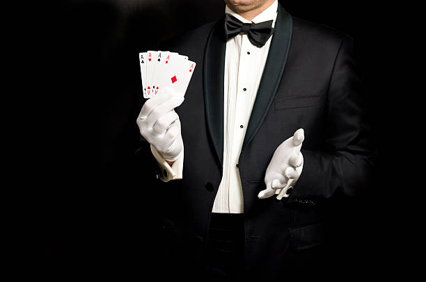 istock Elegant man in tuxedo holding 4 aces in hand 491232428