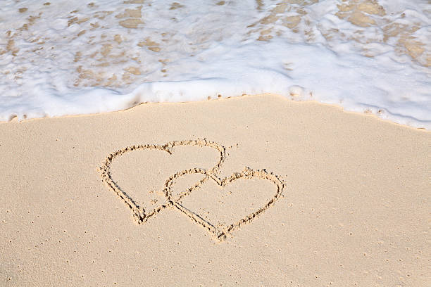 istock Two hearts drawn on the beach sand 491243022