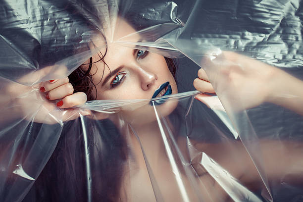 istock Woman with creative eye makeup peering cellophane 491243457