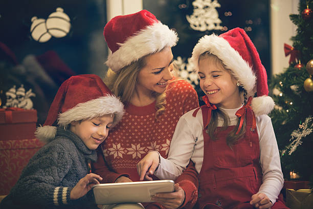 mère et enfants s'amusant sur tablette numérique pour noël - ipad shopping gift retail photos et images de collection