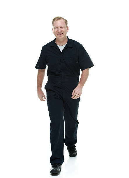 Smiling mechanic walking and looking at camera
