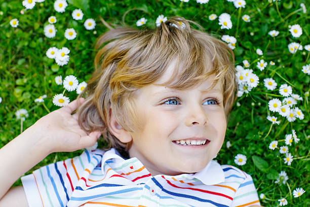 istock Happy kid boy laying on green grass in summer 491244436