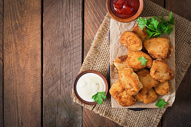 Chicken nuggets and sauce on a wooden background