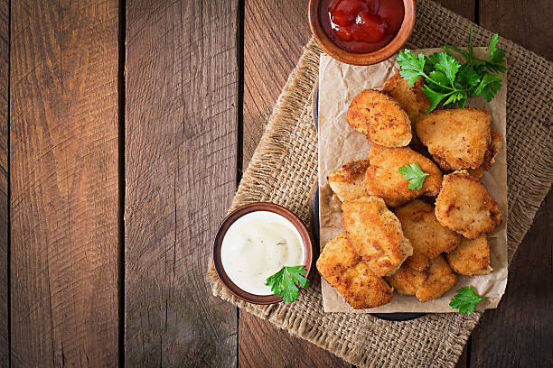 Chicken nuggets and sauce on a wooden background stock photo