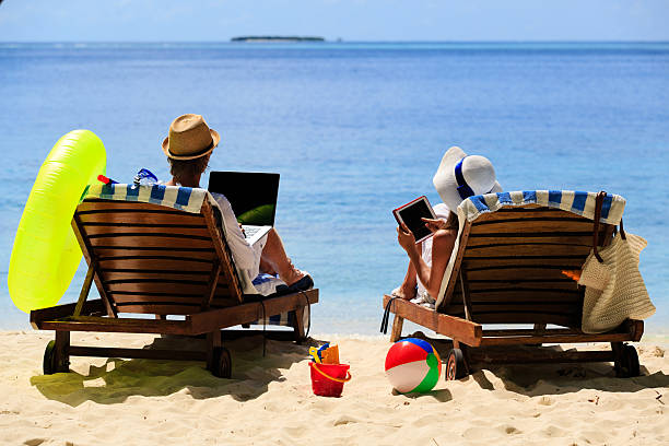 istock happy couple surfing the net and enjoy beach vacation 491245444