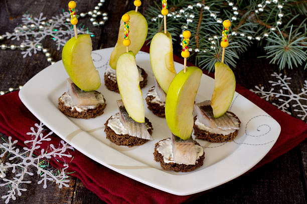 istock Appetizer canape with herring, apples on a dark wooden backgroun 491246388