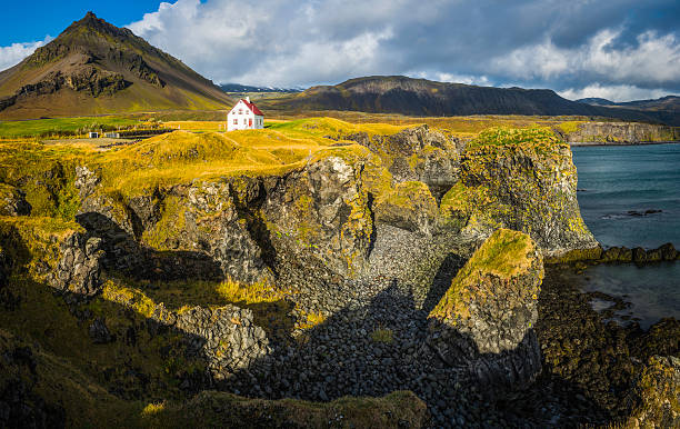 white house über dramatische felsige küste ocean, mountain snaefellsnes island - snaefellsnes stock-fotos und bilder