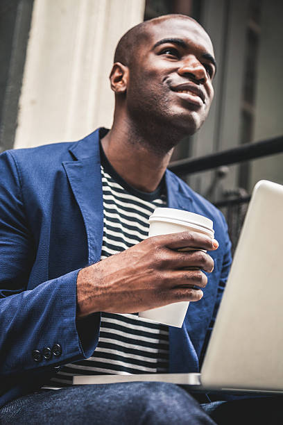istock Man texting on laptop seated on steps on the streets 491249314