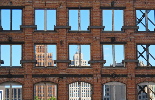 A view of downtown Detroit, seen through brick window frames, as old Detroit makes room for the new.