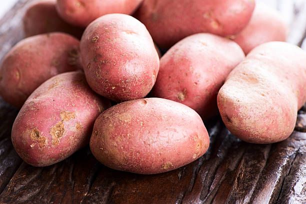 istock potatoes on brown wooden table close-up 491250293