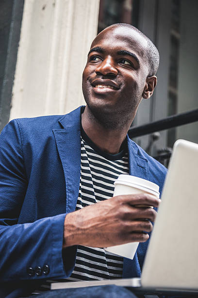 istock Man texting on laptop seated on steps on the streets 491260802