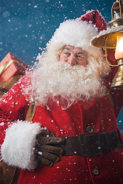 istock Santa Claus outdoors lights the way with vintage lantern 491264502