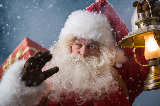 istock Santa Claus outdoors lights the way with vintage lantern 491264676
