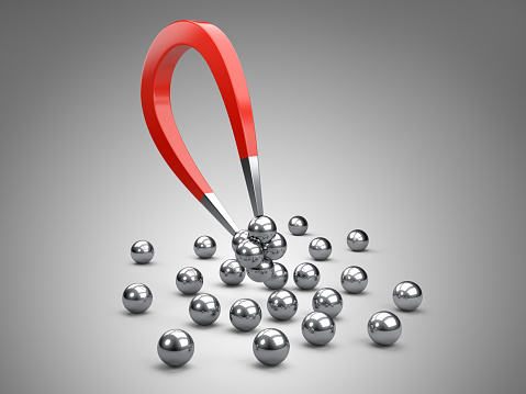 Magnet attracting some chrome ball.  concept for marketing and business leadership