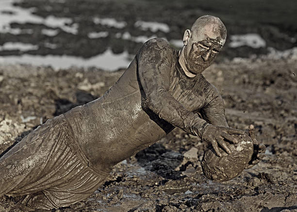 istock rugby player catching ball in mud 491264904