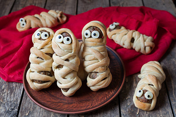 Scary halloween food meatball sausage mummies wrapped in dough with stock photo