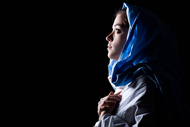 Virgin Mary Virgin Mary with Blue Veil Praying on Black Background virgin mary photos stock pictures, royalty-free photos & images