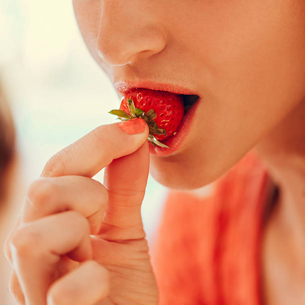 istock Female Eating Strawberries 491266124