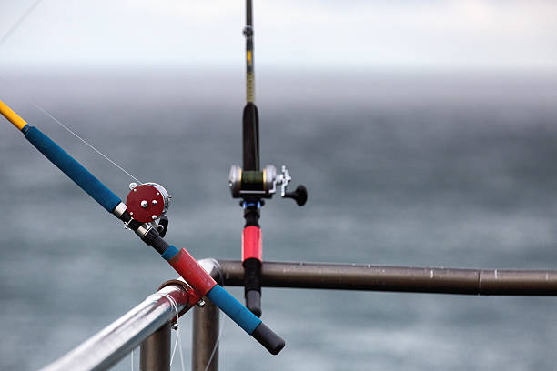 Fishing reel and rod attached to the railing stock photo