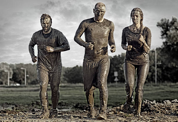 group of people jogging in mud