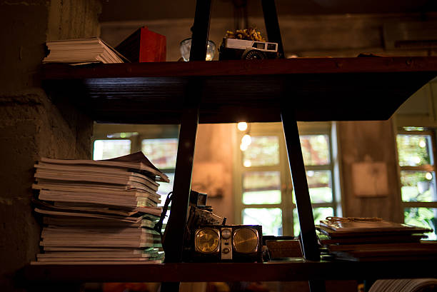 istock Shelf with old books, camera, clock on the vintage background 491275960
