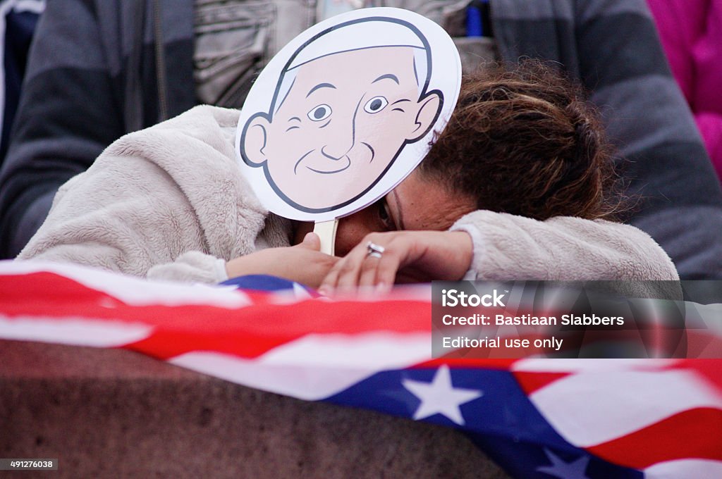 Pope Francis Historic U.S. Visit - Philadelphia Philadelphia, PA, USA - September 26, 2015; Spectator, hit by fatigue from the hour long wait, is seen in attendance of the crowds gathered to witness the Papal parade in center city Philadelphia, Pennsylvania. (photo by Bastiaan Slabbers)  Pope Francis Stock Photo