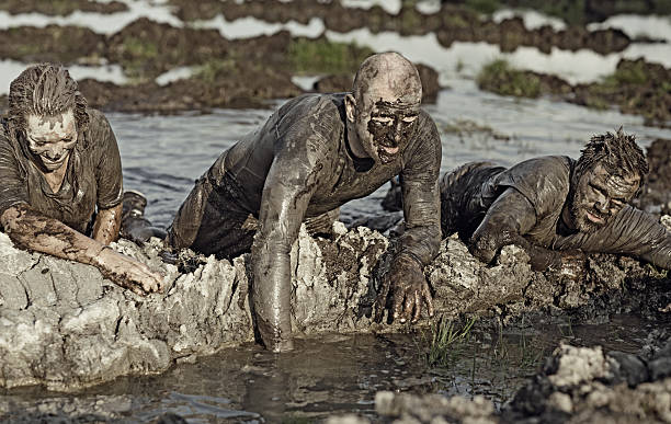 istock group of people crossing mud obstacle 491277362